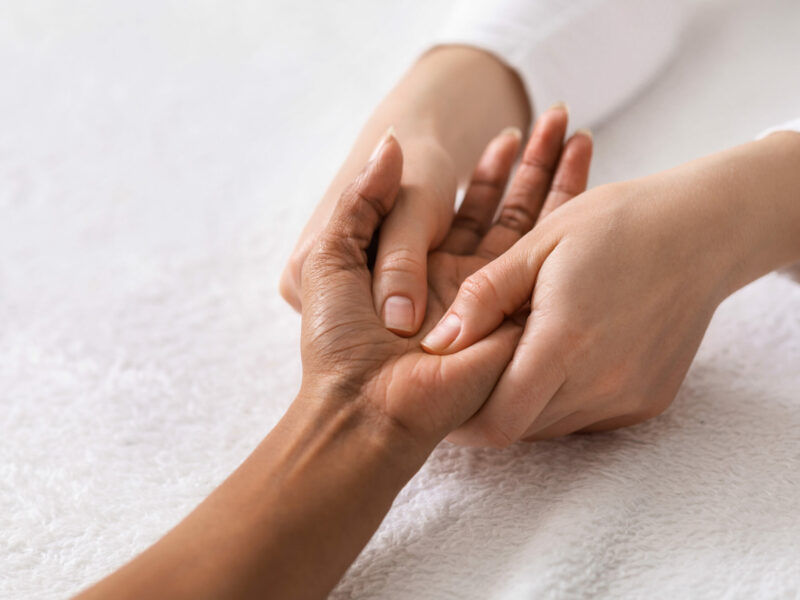 Closeup of acupuncture hand massage for black woman at spa salon, copy space